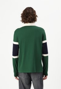 Grønn langermet skjorte med hvite og marineblå striper på ermene, laget av et glatt stoff, med en klassisk kragedesign.