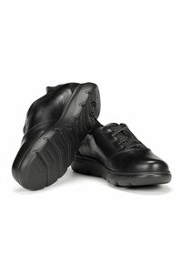 Chaussures en cuir noir avec un bout arrondi et un design à lacets. Semelle en caoutchouc noir texturé avec un motif de crantage pour l'adhérence et la durabilité.