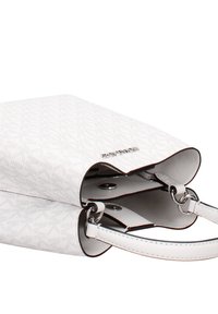 Sac à main blanc avec surface texturée, doté de ferrures argentées, de deux poignées supérieures et d'une fermeture à pression magnétique. Structure intérieure notable visible.