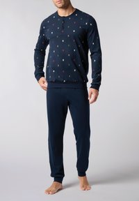 Completo pigiama navy composto da una maglietta a maniche lunghe con collo henley abbottonato e motivi multicolore disposti casualmente, abbinato a pantaloni coordinati.