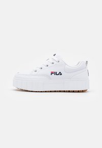 Sneaker bianca con suola a piattaforma, punta rotonda, chiusura con lacci e dettaglio del logo Fila; materiale sintetico liscio con suola in gomma testurizzata.