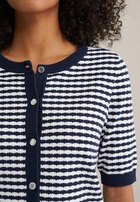 Marinblå och vit randig kortärmad kofta med rund halsringning, som har tre tryckknappar och ett strukturerat stickat mönster.