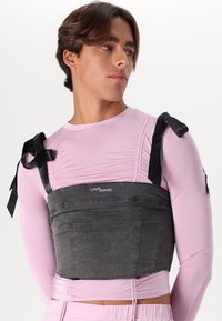 Sivý denimový crop top so štruktúrovaným dizajnom, ktorý má čierne saténové ramienka a ružovú základnú vrstvu s dlhým rukávom s nazhromaždenými detailmi.