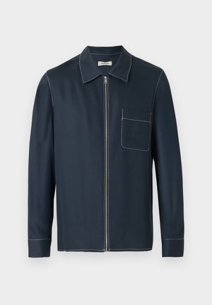Donkerblauw hemdjack met lange mouwen, kraag, ritssluiting aan de voorkant, één borstzak en witte contrasterende stiknaden langs de naden en randen.