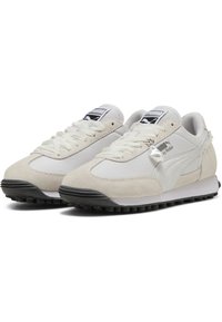 Baskets blanches et grises en daim et mesh avec une semelle en caoutchouc noire, arborant un logo proéminent, une fermeture à lacets et un bout arrondi.