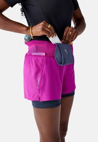 Women's pink running shorts with mesh pockets, designed for storage. Features a blue fabric accent and shorter leg length for comfort.