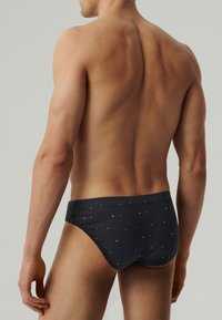 Męskie kąpielówki w ciemnoszarym kolorze, z subtelnym wzorem małych, kolorowych kropek, niskim krojem i elastycznym pasem.