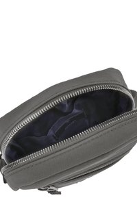 Grå stof crossbody taske med lynlås lukning og indvendig foring. Har en glat overflade og en sølvfarvet lynlåsdetalje.