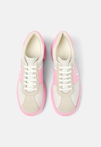 Tenisky s kombinací růžové, krémové a béžové materiály, s texturovaným semišovým svrškem, bílými akcenty a gumovou podrážkou.