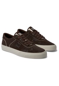 Bruna mocka sneakers med vita detaljer, rund tå, perforerade sidor och flat gummisula. Utformade med snören och logotyp på sidan.