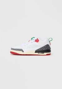 Białe sneakersy z czarnymi i szarymi akcentami w wzór słoniowej skóry, czerwonym spodem, zielonymi i czerwonymi oczkami oraz widoczną poduszką powietrzną w pięcie.