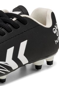 Zwarte voetbalschoenen met een gestructureerde bovenkant, witte accenten en een flexibele zool. Beschikt over zwarte noppen en een gevoerde kraag voor comfort.