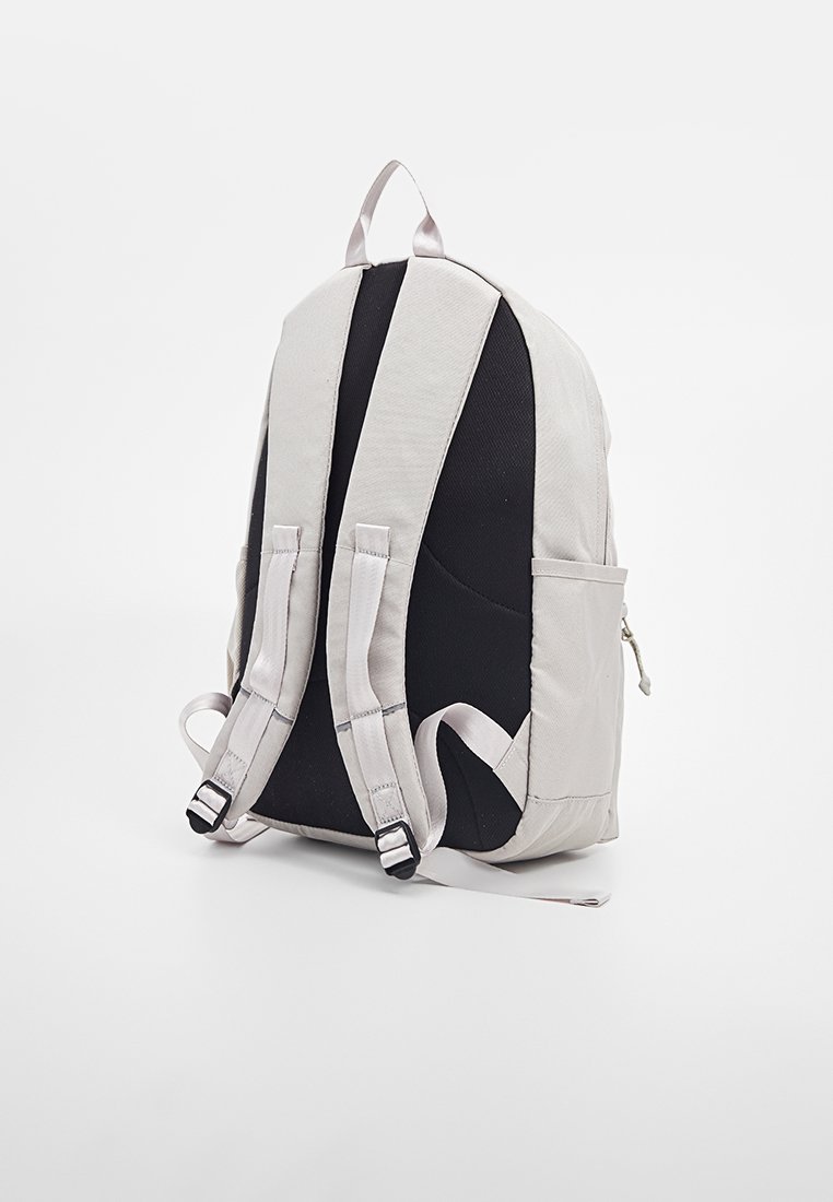 Lichtgrijze en zwarte stoffen rugzak met gevoerde banden, een ritsvak en een gestructureerd, semi-gestructureerd ontwerp.