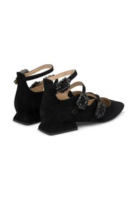 Schwarze Wildlederschuhe im Ballerina-Stil mit mehreren dünnen Riemen und dekorativen schwarzen Edelsteinakzenten an der Seite. Niedrige, kantige Absätze.