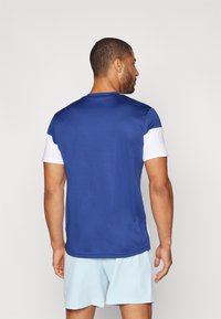 Sport-T-Shirt in Blau mit weißen kurzen Ärmeln, aus atmungsaktivem Stoff gefertigt. Verfügt über einen Rundhalsausschnitt und eine glatte Textur.