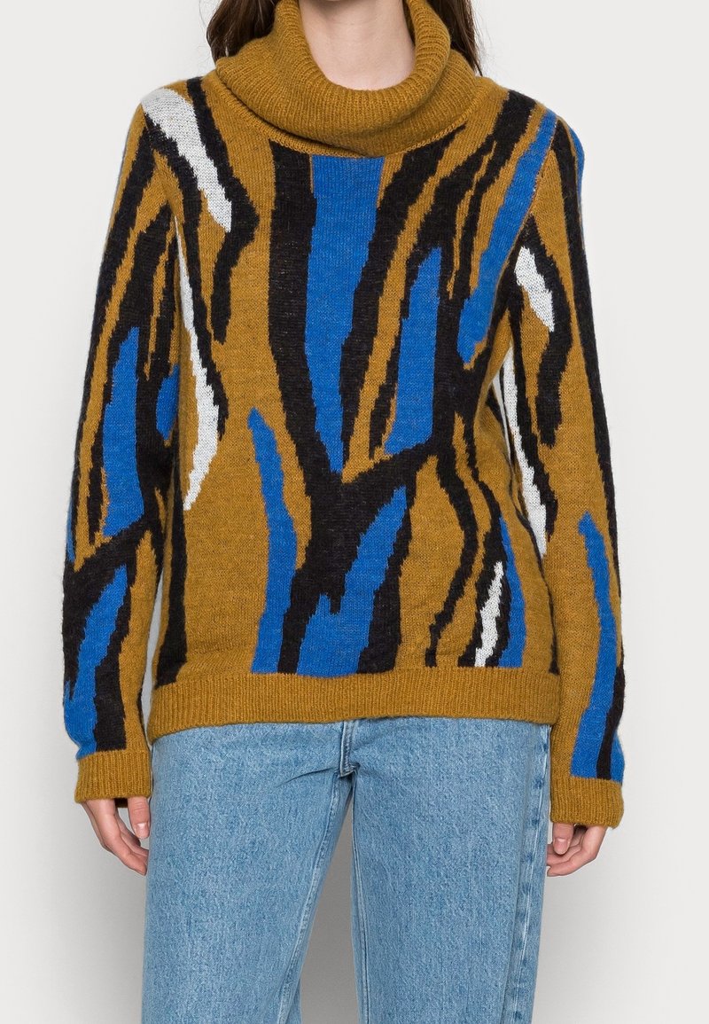Sweter z dzianiny wełnianej z golfem, w wyraziste abstrakcyjne wzory w kolorach pomarańczowym, niebieskim, czarnym i białym; wykończony ściągaczami na mankietach i na dole.