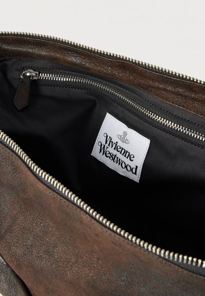 Εσωτερικό καφέ δερμάτινης τσάντας με μαύρη επένδυση, ασημένιο φερμουάρ και λευκή ετικέτα Vivienne Westwood ραμμένη μέσα.
