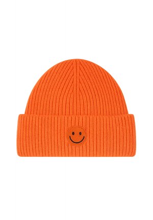 Helles orangefarbenes geripptes Strickbeanie mit umgeschlagenem Rand und kleinem schwarzem Smiley-Patch vorne in der Mitte.