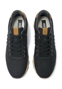 Schwarze Sportschuhe mit perforiertem Lederoberteil, flachen Schnürsenkeln, braunen Akzenten an der Ferse und einer beigen gepolsterten Sohle.