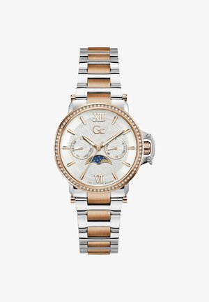 Hõbedane ja roosakaskuldne käekell kristallidega raamitud sihverplaadiga, kuu faasi, päeva ja kuupäeva lisakettidega ning Rooma numbritega XII ja VI tekstureeritud sihverplaadil.