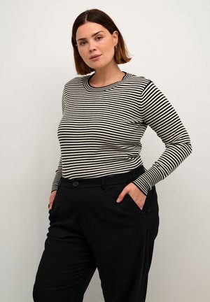 Black and cream striped long-sleeve top with a round neckline, paired with black trousers featuring pockets and a button closure.
