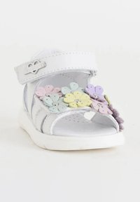 Sandalo bianco con cinturino in velcro, caratterizzato da fiori multicolori nei toni di rosa, viola, giallo e blu. Materiale morbido, suola piatta.