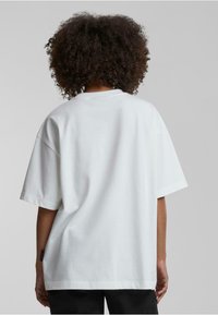 Hvit oversized t-skjorte med korte ermer, laget av myk bomull. Enkel design, rund utringning, og ingen synlige mønstre eller aksenter.