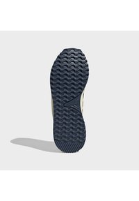 Suela de zapato de goma en color navy con una textura estampada, que presenta líneas onduladas en relieve y un acento de logotipo central. Forma redondeada con una base ancha.