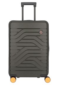 Valigia rigida di colore verde scuro con design testurizzato ondulato, manico retrattile, quattro ruote con accenti arancioni e logo del marchio.