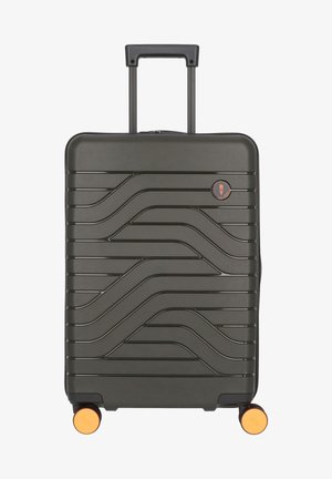 Valigia rigida di colore verde scuro con design testurizzato ondulato, manico retrattile, quattro ruote con accenti arancioni e logo del marchio.