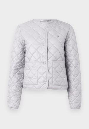 Gray quilted jacket featuring a round neckline, snap buttons, two front pockets, and a smooth texture with a subtle logo accent.