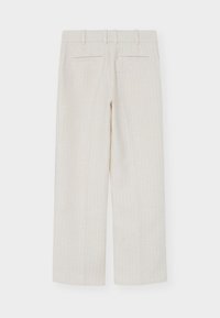Pantalon droit texturé blanc cassé avec passants de ceinture et deux poches passepoilées à l'arrière sur un fond uni.