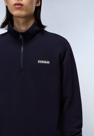 Navy blue half-zip pullover made of textured fabric. Features a small white logo on the chest and a stand-up collar.
