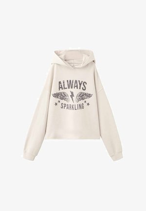 Svetlo bež obrezana jopa iz mehkih materialov s grafičnim potiskom z besedami "VEDNO SIJA", krili in zvezdami.