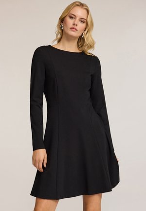 Abito lungo nero a maniche lunghe con scollo rotondo, gonna a ruota e design senza cuciture, realizzato in tessuto liscio senza motivi o accenti visibili.