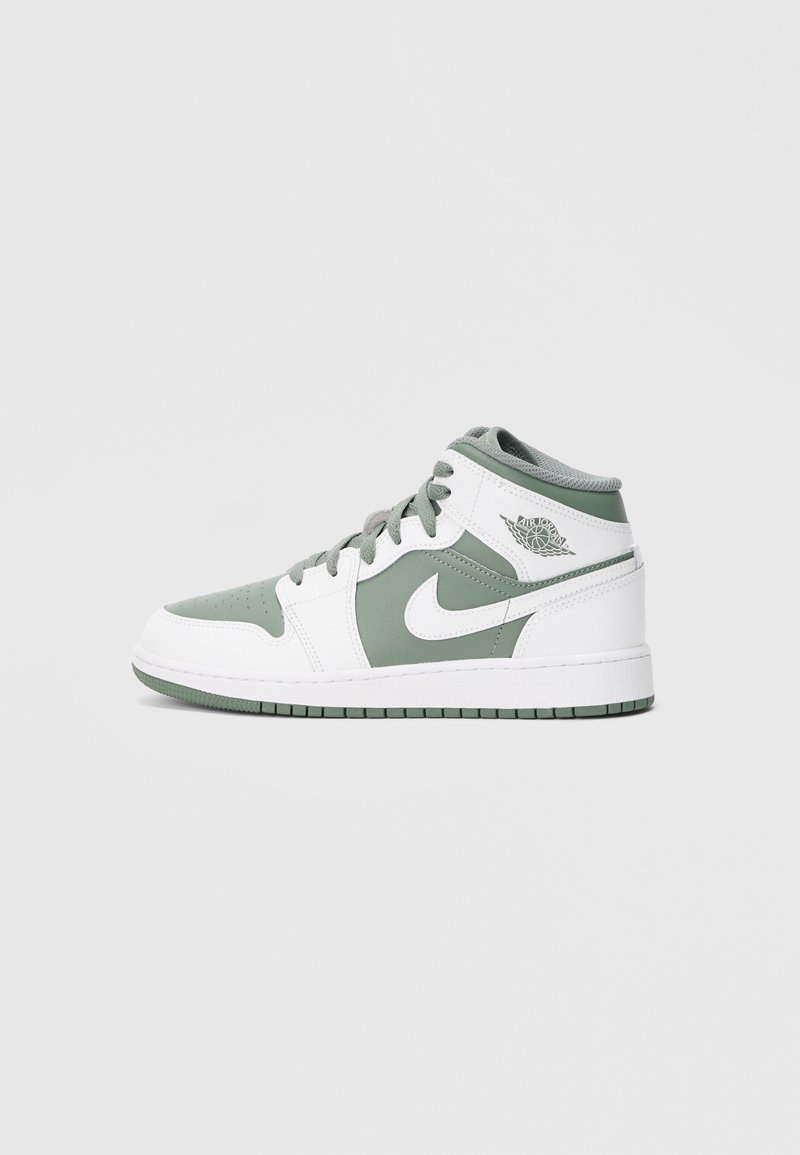 Baskets montantes Nike Air Jordan blanches et vert pâle avec lacets, logo de la marque sur le côté et semelle visible sur fond clair uni.