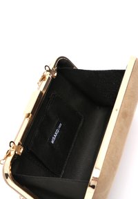 Pochette en daim beige avec un cadre et un fermoir en métal doré. L'intérieur présente une doublure en tissu noir et une petite poche pour cartes.