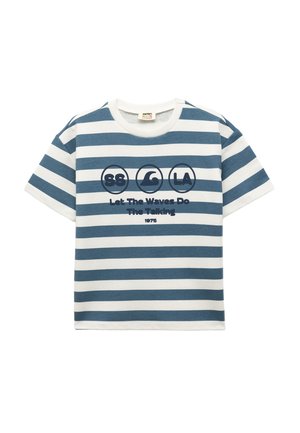 Camiseta de manga corta a rayas azul y blanca, con un cuello redondo y un texto gráfico: "Deja que las olas hablen 1975" en azul marino.