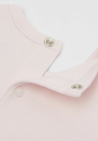 Světlý růžový bavlněný body s kovovými druky na límci a rameni, s žebrovanou texturou a kulatým výstřihem.