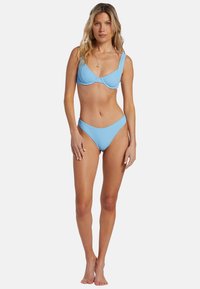 Ljusblå rippad bikini-set som innehåller en bralette-aktig topp med breda axelband och högmidjade underdelar, båda i en strukturerad finish.
