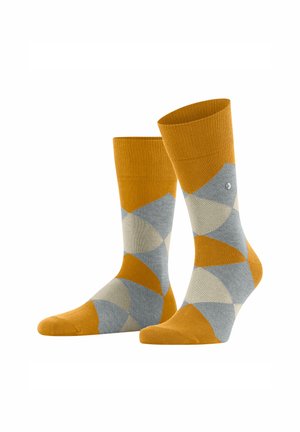 Gelbe und grau gemusterte Socken mit einem geometrischen Design, die kontrastierende Farbtöne und eine weiche Stricktextur aufweisen.
