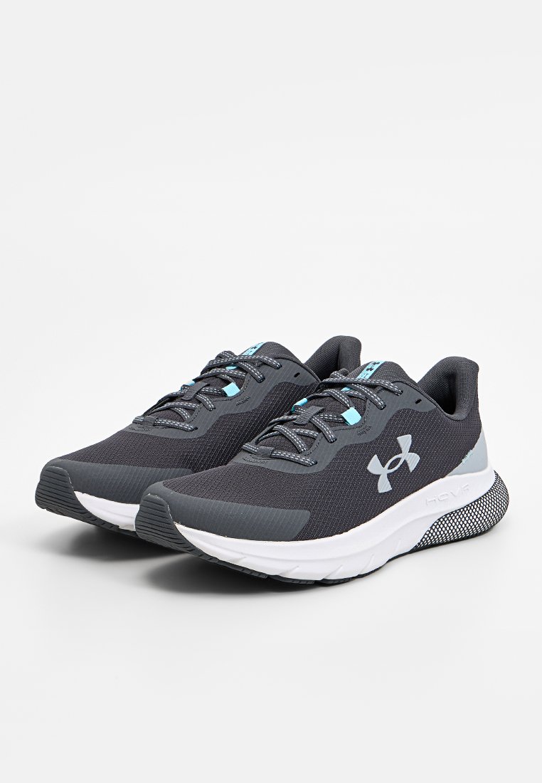Zapatillas deportivas negras hechas de malla transpirable con acentos grises. Presentan una puntera redondeada, un collar acolchado y una suela de goma texturizada.