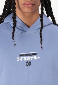 Light blue hoodie with a drawstring, featuring a graphic print that includes text and a spiral symbol on the front. Smooth texture.