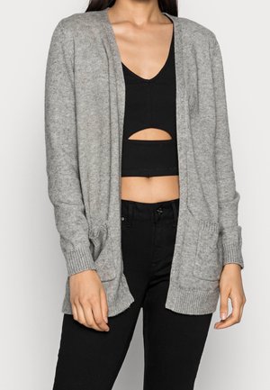 Cardigan grigio lavorato a maglia con apertura frontale, polsini a coste e due tasche frontali. Texture morbida e vestibilità rilassata, ideale per essere indossato a strati.