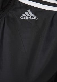 Black athletic shorts with a smooth texture, featuring white stripes and a silver Adidas logo on the left side.
