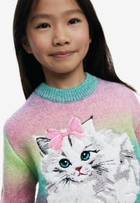 Mehrfarbiger Pullover mit einem Farbverlauf von Rosa zu Grün, der eine flauschige weiße Katzengrafik mit blauen Augen und einer pinken Schleife zeigt. Strukturierter Strickdesign.