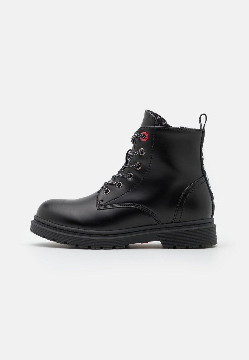 Black leather ankle boots with a round toe, textured finish, lace-up front, red eyelet accents, and a textured rubber sole.