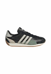 Black leather and green suede sneaker with three white stripes, rubber sole, and a textured finish on the toe and heel.