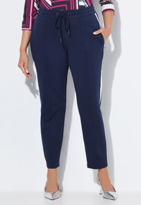 Marineblauwe joggers met zijstrepen, elastische tailleband, verstelbare koord en voorkeurszakken. Zachte, rekbare stof.