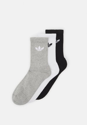 Tri par socks za posadko: sivi z belim logotipom, beli s črnim logotipom in črni z belim logotipom. Celo površino pokriva rebrast vzorec.